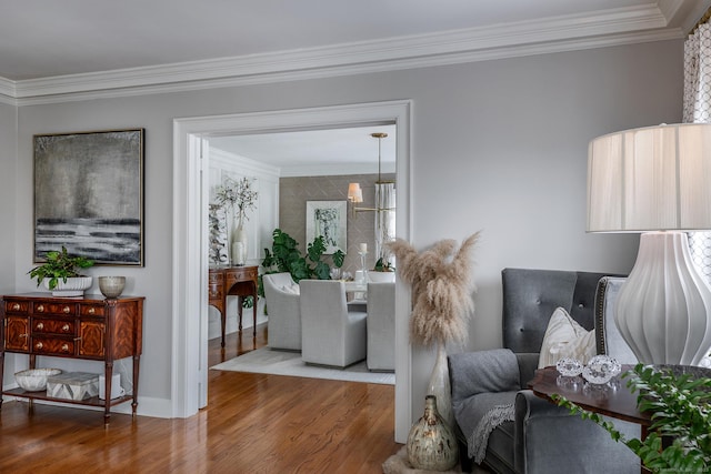 living room with crown molding, baseboards, and wood finished floors