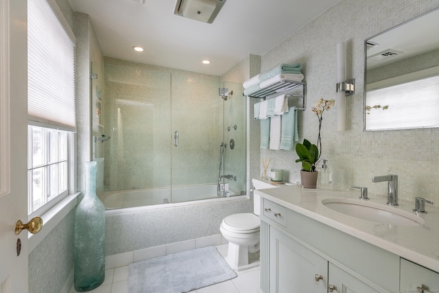 full bathroom with tile walls, visible vents, enclosed tub / shower combo, vanity, and tile patterned floors