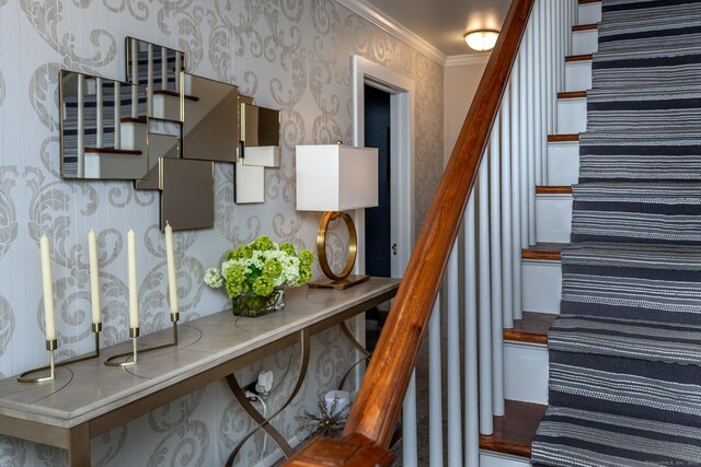 stairway featuring wallpapered walls and crown molding