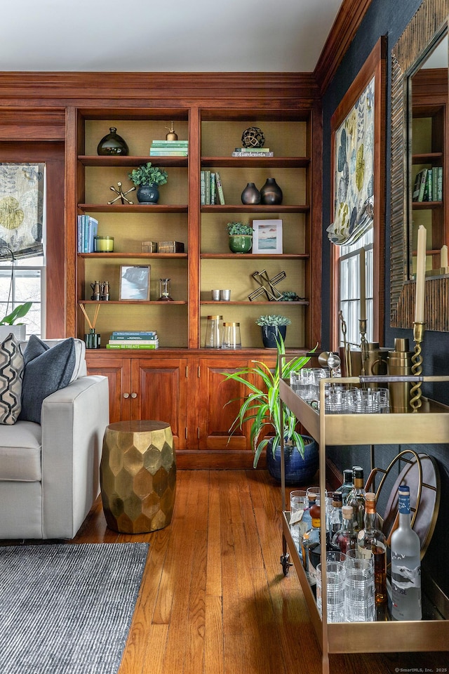 sitting room with hardwood / wood-style flooring and built in shelves