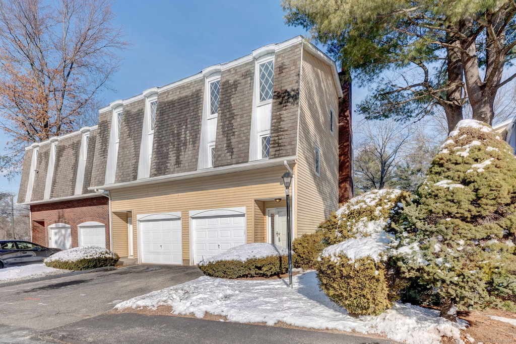 view of snowy exterior with a garage