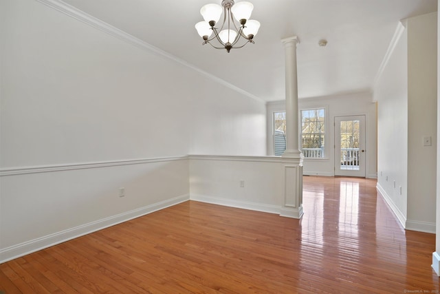 unfurnished room with hardwood / wood-style floors, decorative columns, and ornamental molding