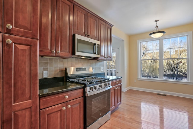 kitchen featuring light hardwood / wood-style flooring, decorative light fixtures, stainless steel appliances, and backsplash