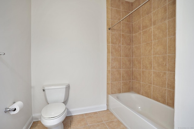 bathroom featuring tiled shower / bath, toilet, and tile patterned floors