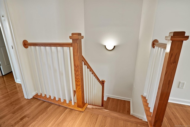 staircase with hardwood / wood-style flooring