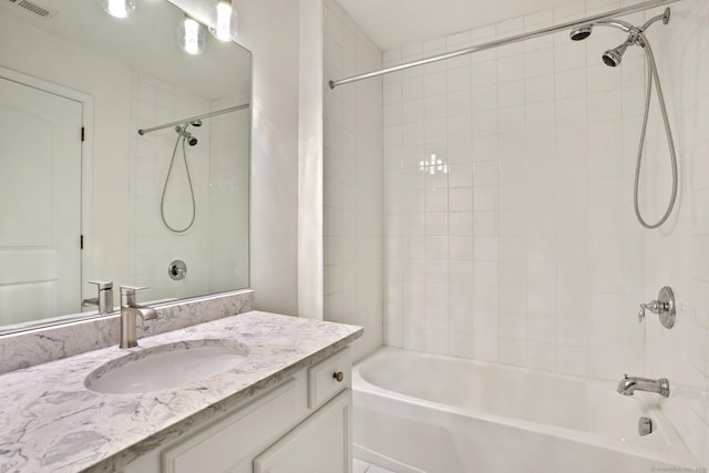 bathroom featuring vanity and tiled shower / bath