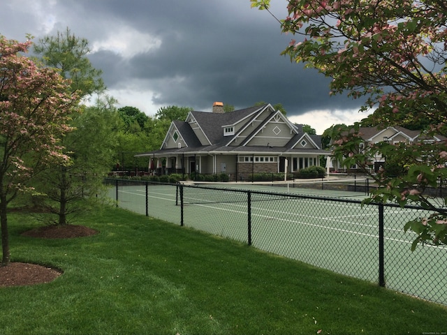 view of tennis court featuring a yard