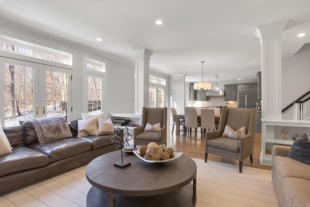 living room featuring decorative columns, french doors, and crown molding