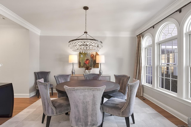 dining room with ornamental molding, light wood-type flooring, and an inviting chandelier