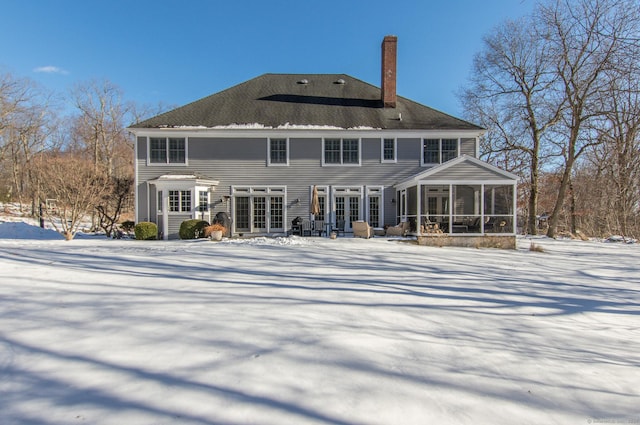 snow covered property with a sunroom