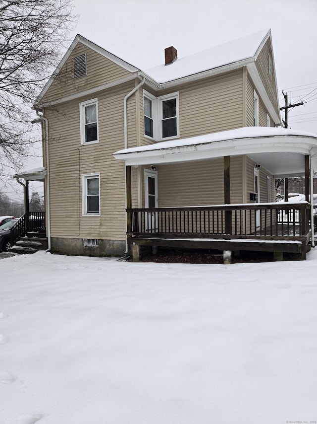 view of front of house featuring covered porch and a chimney