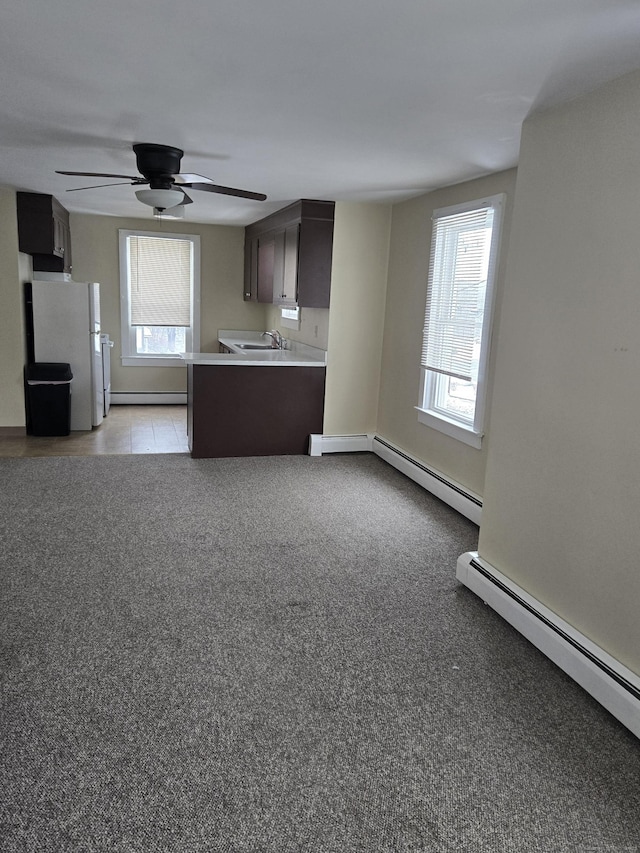 interior space with freestanding refrigerator, light countertops, plenty of natural light, and a sink