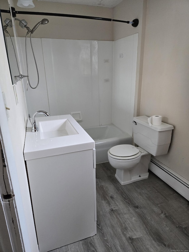 full bathroom featuring bathing tub / shower combination, toilet, vanity, wood finished floors, and washer / dryer