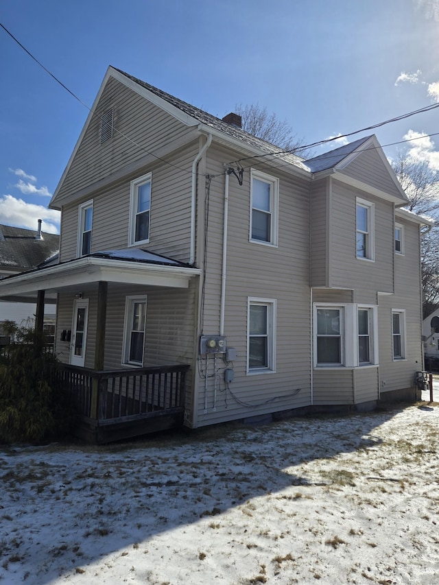 exterior space with a porch and a chimney