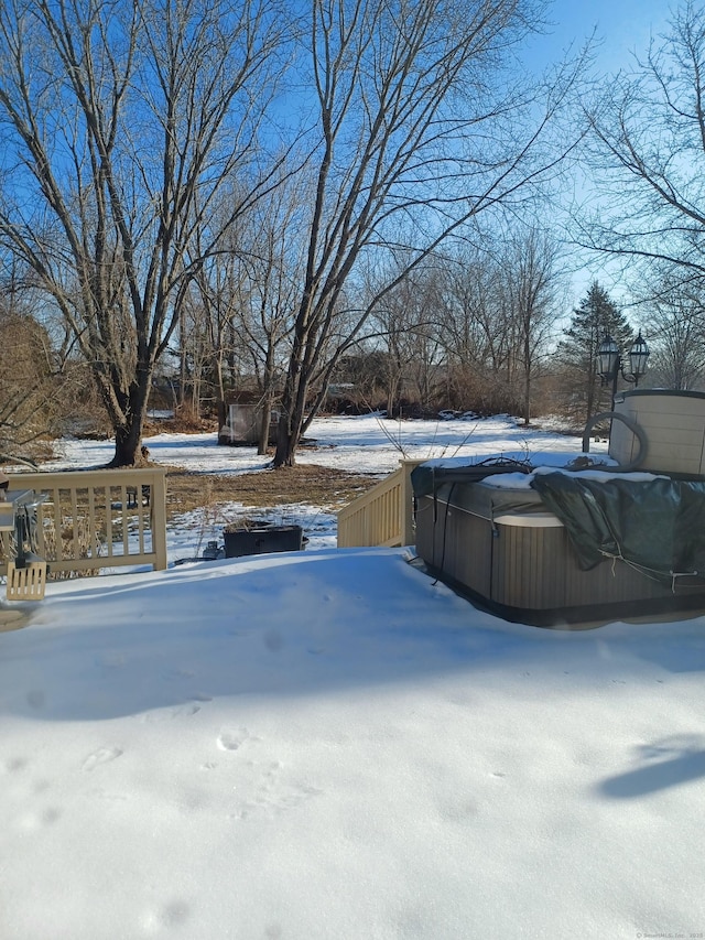 snowy yard featuring a hot tub