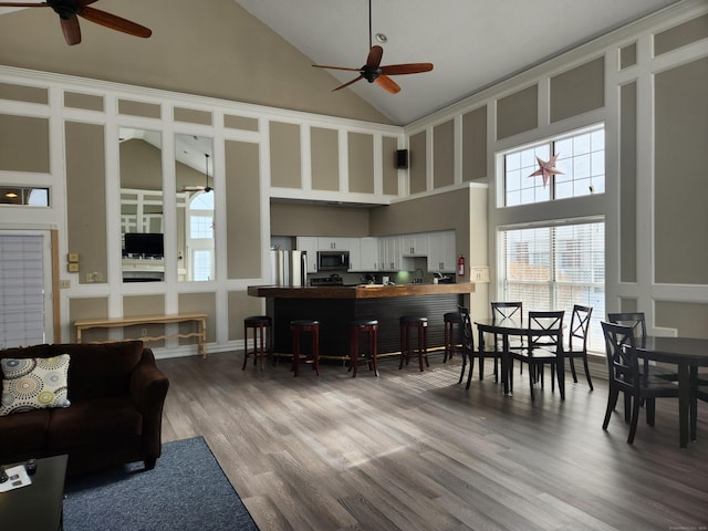 interior space with stainless steel appliances, a ceiling fan, white cabinets, open floor plan, and light wood finished floors