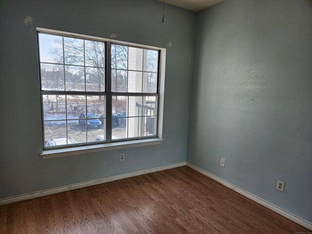 empty room with baseboards and wood finished floors