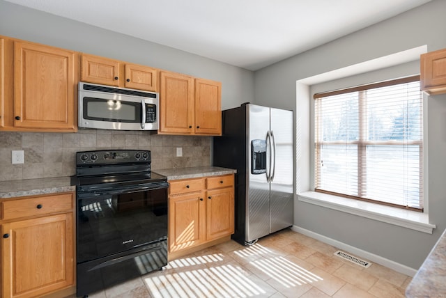 kitchen with tasteful backsplash, stainless steel appliances, and light brown cabinets