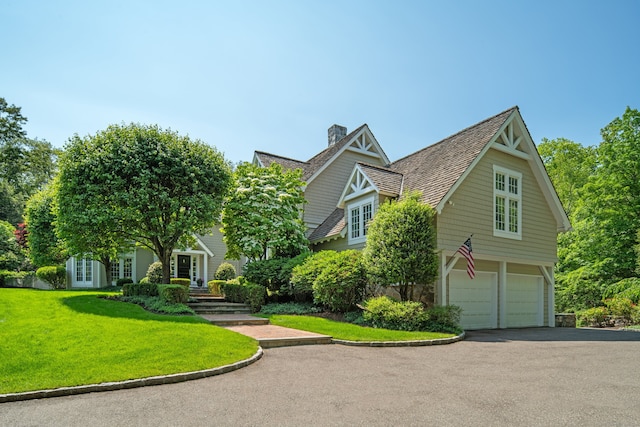 4 Hemlock Rdg, Weston, CT 06883 - view of front facade featuring a chimney, an attached garage, french doors, driveway, and a front lawn