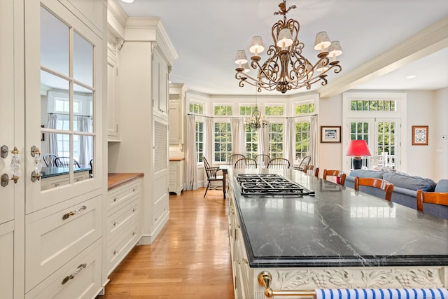 4 Hemlock Rdg, Weston, CT 06883 - kitchen featuring stainless steel gas cooktop, a chandelier, light wood-style flooring, white cabinets, and hanging light fixtures