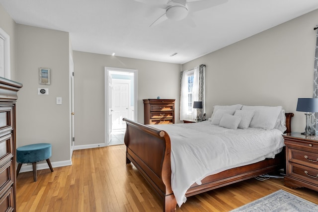 bedroom with baseboards, a ceiling fan, and light wood-style floors