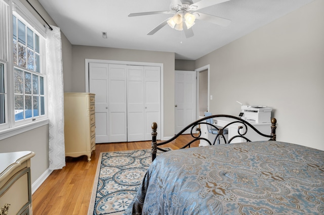 bedroom with light wood-type flooring, a ceiling fan, and a closet