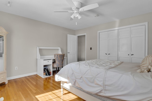 bedroom featuring light wood-style floors, a closet, baseboards, and a ceiling fan