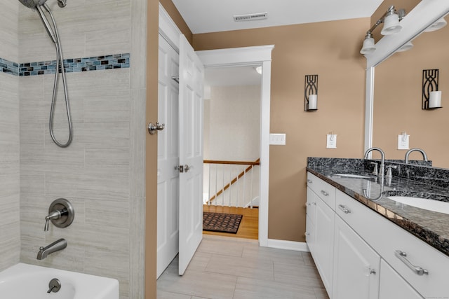 full bathroom featuring double vanity, bathing tub / shower combination, a sink, and visible vents