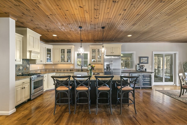 kitchen with dark stone counters, glass insert cabinets, stainless steel appliances, and a center island