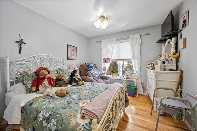 bedroom featuring baseboards and wood finished floors