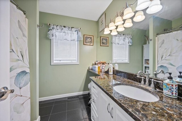 bathroom featuring visible vents, tile patterned flooring, vanity, and baseboards