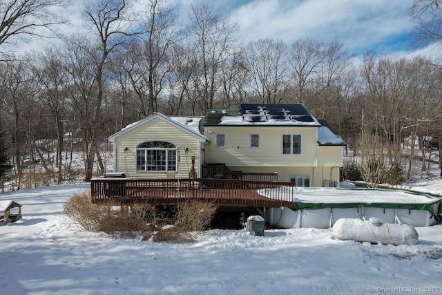 snow covered rear of property featuring a wooden deck