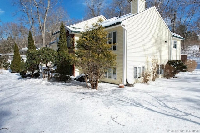 snow covered property featuring a chimney