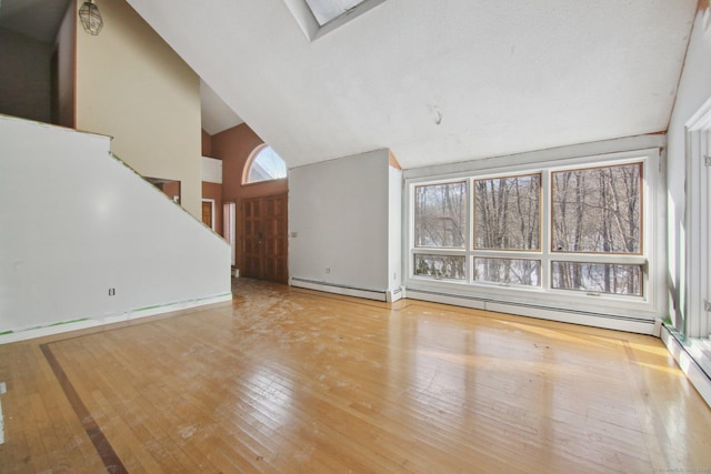 unfurnished living room featuring light wood finished floors and high vaulted ceiling