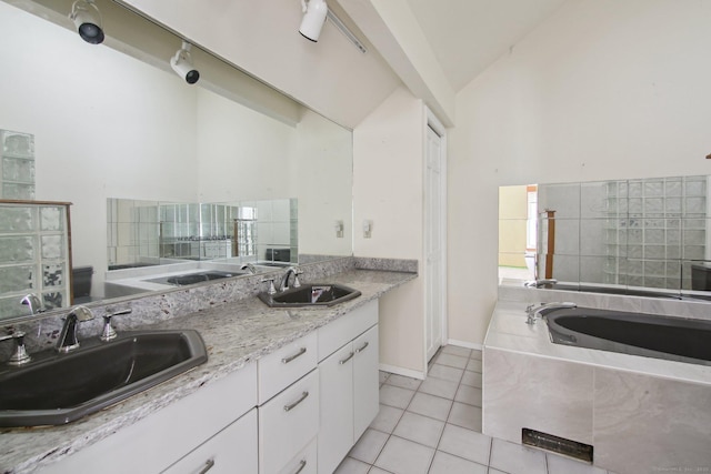 interior space with lofted ceiling, a sink, a bath, and tile patterned floors