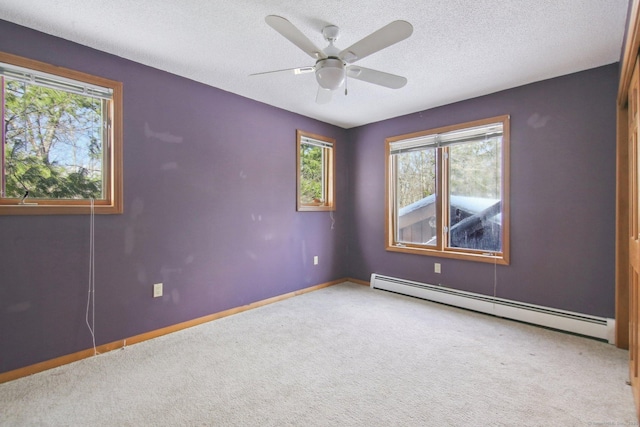 spare room with a textured ceiling, a baseboard radiator, carpet flooring, and baseboards