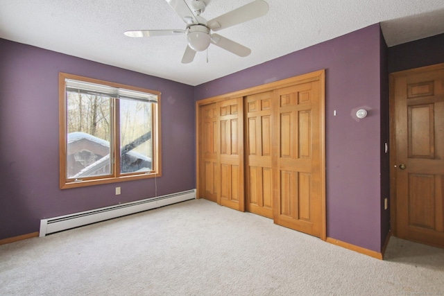 unfurnished bedroom with light carpet, a textured ceiling, a baseboard radiator, and a closet