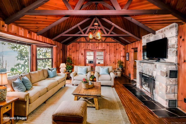 living area featuring vaulted ceiling with beams, wooden walls, wood-type flooring, and a fireplace