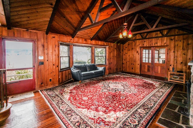 unfurnished living room featuring a healthy amount of sunlight and wood walls