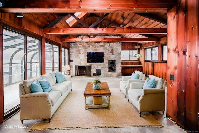 living room featuring a ceiling fan, wood ceiling, vaulted ceiling with beams, wood walls, and a fireplace