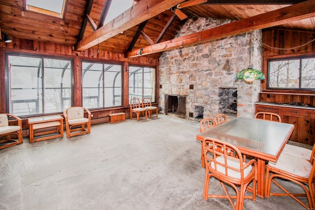 interior space featuring a wealth of natural light, wooden ceiling, a fireplace, and lofted ceiling with beams