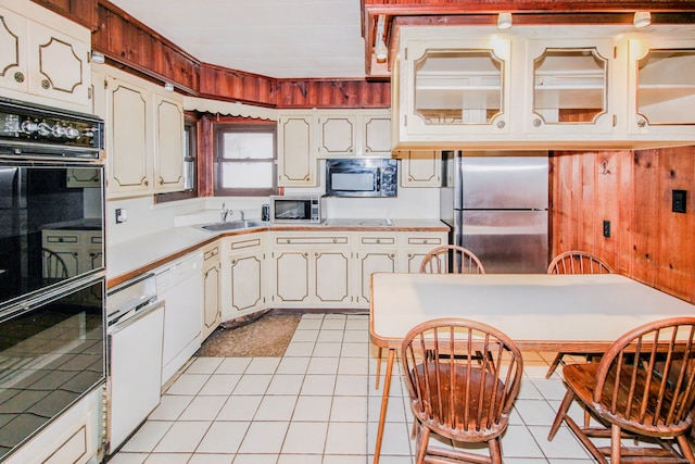 kitchen with light tile patterned floors, appliances with stainless steel finishes, light countertops, and a sink