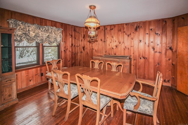 dining space with wood-type flooring and wooden walls