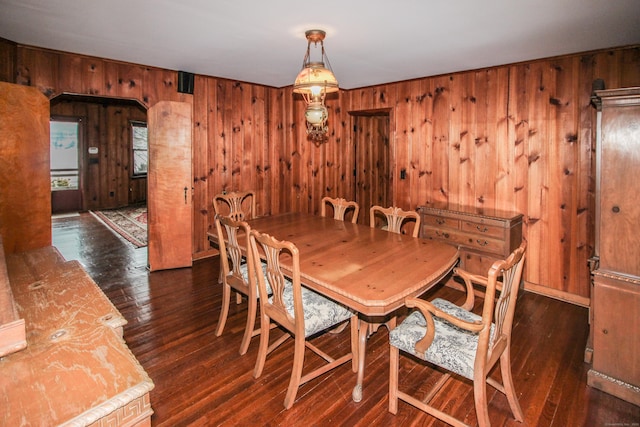 dining space featuring wood walls and wood-type flooring