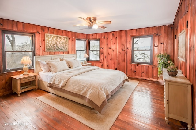 bedroom with a ceiling fan, multiple windows, and light wood finished floors