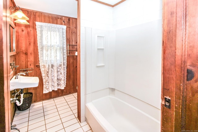 full bath with shower / bathtub combination, wood walls, tile patterned flooring, and a sink