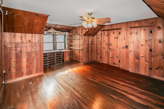 bonus room featuring ceiling fan, wooden walls, and hardwood / wood-style floors