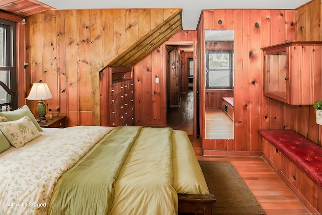 bedroom featuring wood walls and wood finished floors