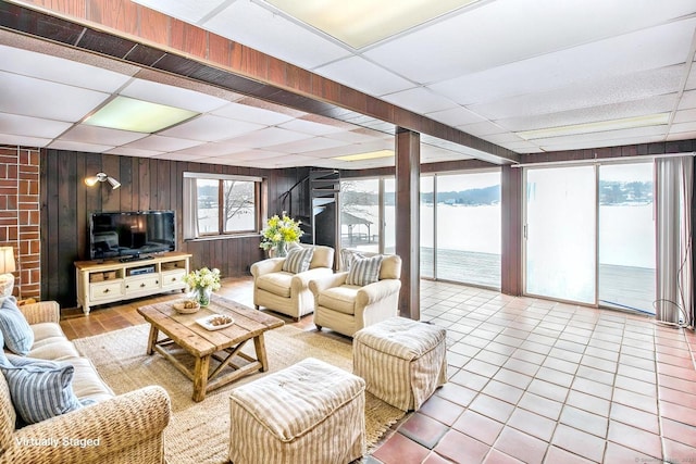 tiled living room with a paneled ceiling and wooden walls