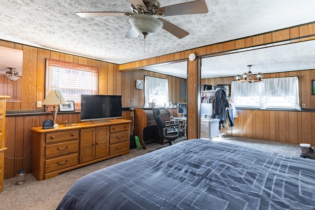 carpeted bedroom with wooden walls, a textured ceiling, and an inviting chandelier